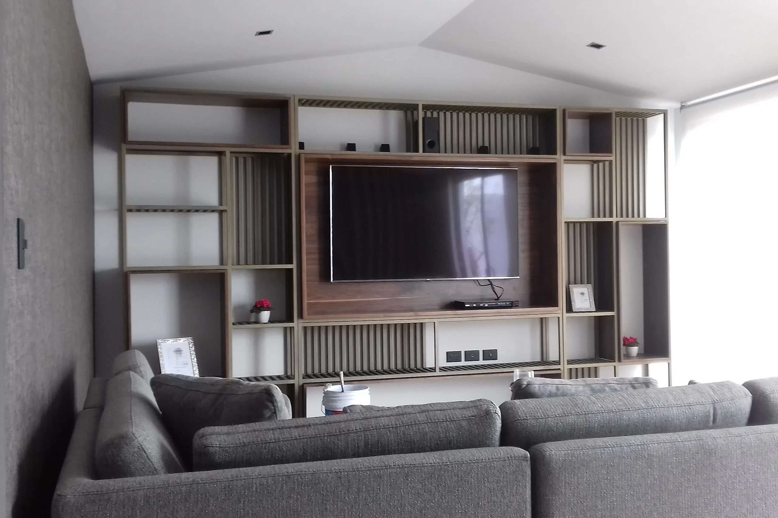 Mueble de muro para la sala con nichos abiertos, listones y panel para la pantalla