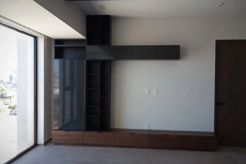 Mueble de TV con base de madera y módulos lacados en negro hasta el plafón